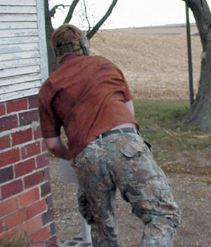 Joe Anastasi throwing paintballs at a tree