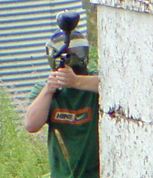 Josh Carlson behind a tree aiming at the camera